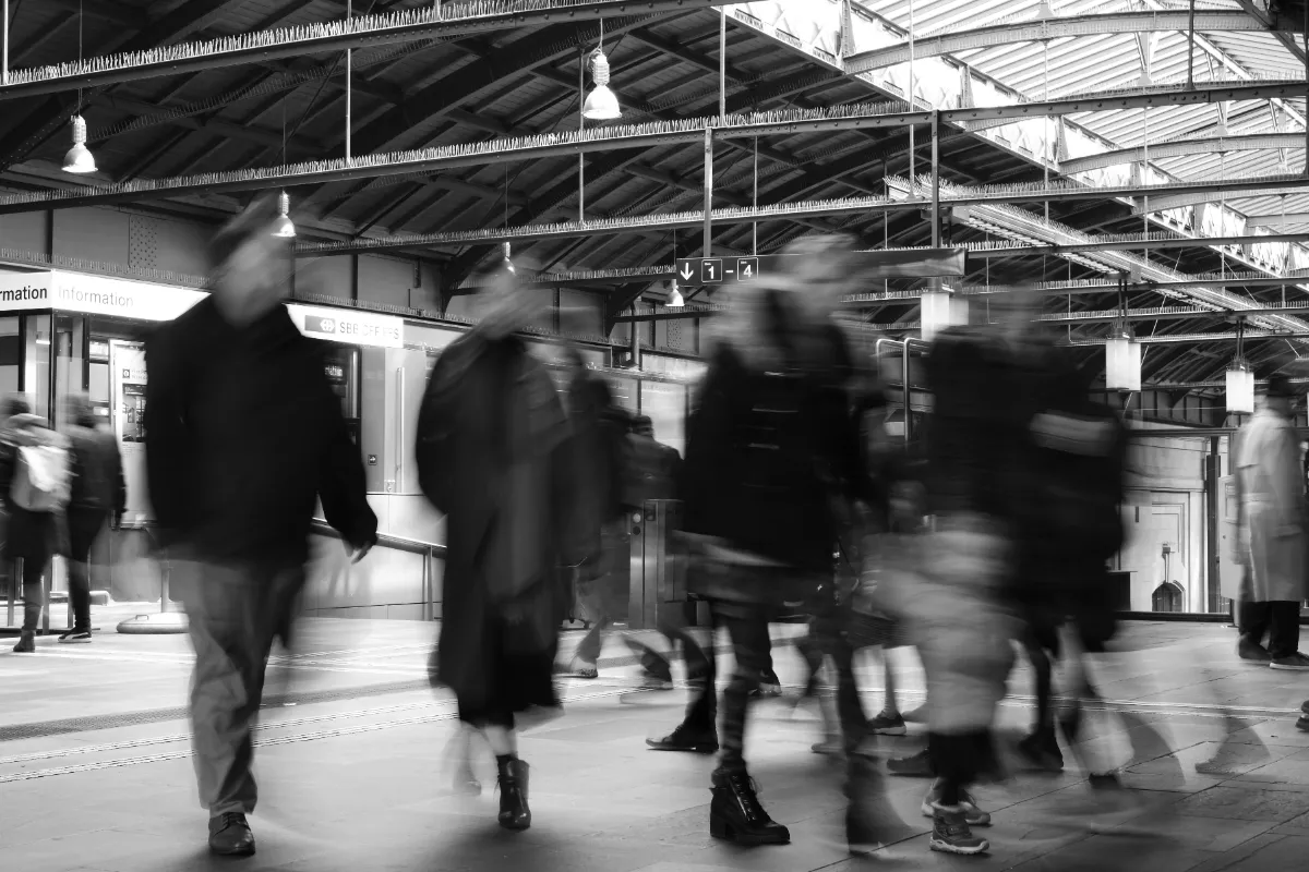 A crowded, blurred train station platform full of moving commuters, evoking the cluttered feeling of an ad-heavy webpage